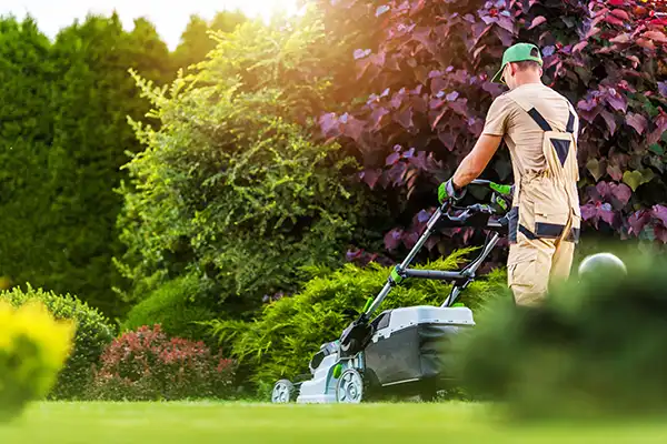 A landscaper diligently mowing a lawn A landscaper diligently mowing a lawn