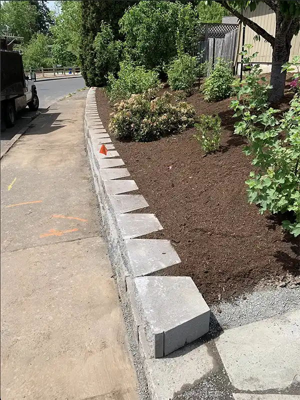 Some mulching work in a client's yard by a wall
